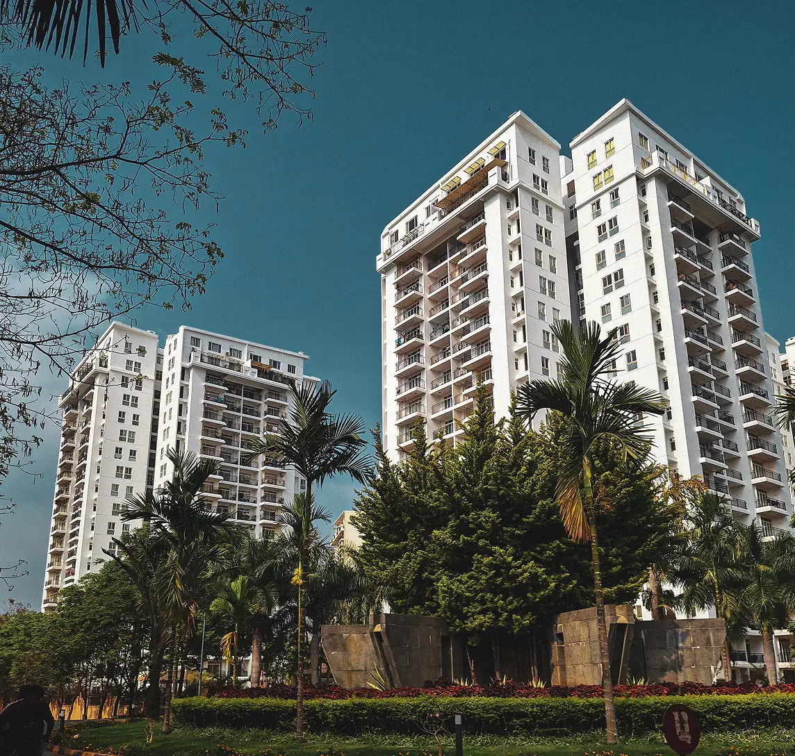 Modern residential apartment buildings along Sarjapur Road with landscaped greenery